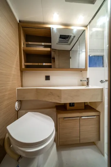 Watercolor Yacht Photos Pics Modern bathroom in 2023 Lagoon 46 yacht with sleek fixtures and wooden cabinetry.