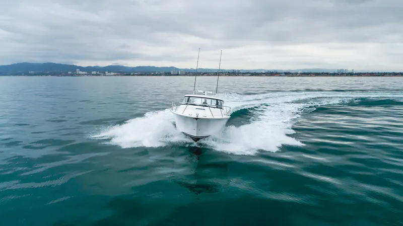 Commodore Two Yacht Photos Pics 2023 Mag Bay 42 Express cruising on open water under cloudy skies.