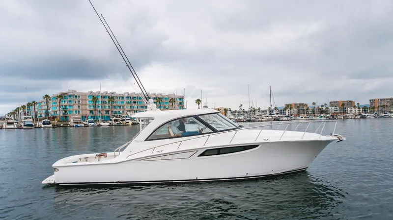 Commodore Two Yacht Photos Pics 2023 Mag Bay 42 Express yacht on calm water with marina backdrop.