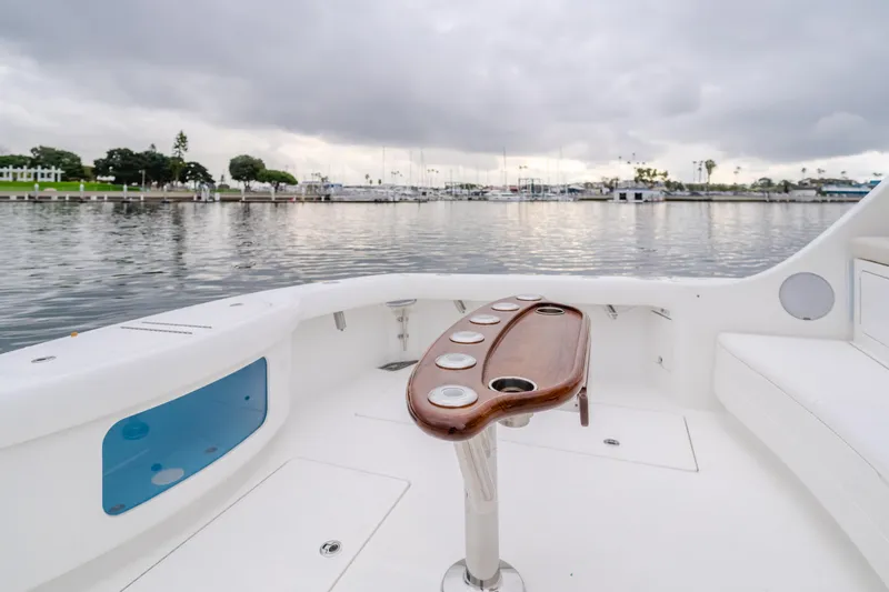 Commodore Two Yacht Photos Pics 2023 Mag Bay 42 Express boat deck with rod holders, overlooking a calm marina.