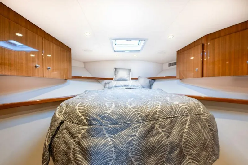 Miss Peggy Sue II Yacht Photos Pics Luxurious cabin interior of 2018 Viking 44 Open yacht with elegant bedding and wood cabinetry.