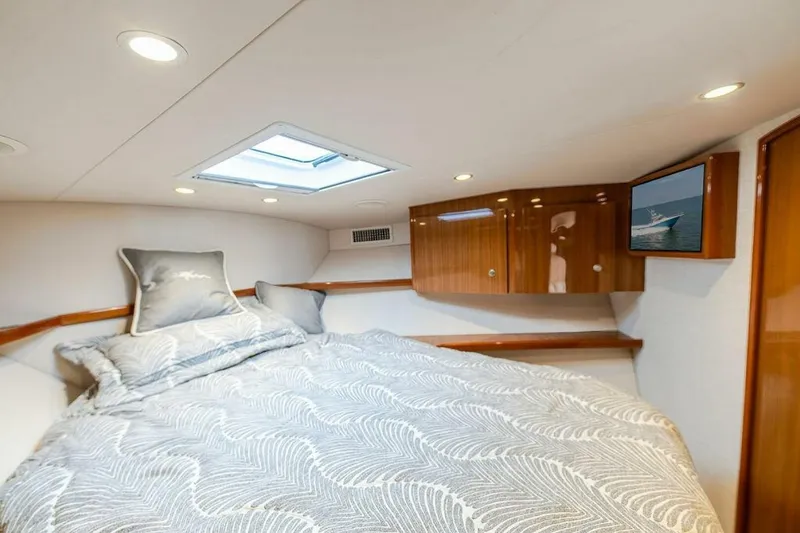 Miss Peggy Sue II Yacht Photos Pics Luxurious cabin interior of 2018 Viking 44 Open yacht with elegant bedding and wood finishes.
