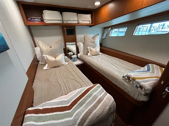 Novia II Yacht Photos Pics Twin cabin interior of 2020 Marlow Explorer 66E yacht with cozy bedding and wooden accents.