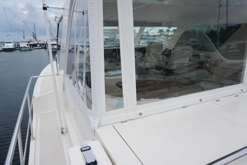 Novia II Yacht Photos Pics 2020 Marlow Explorer 66E yacht, side view, docked at marina with visible interior.