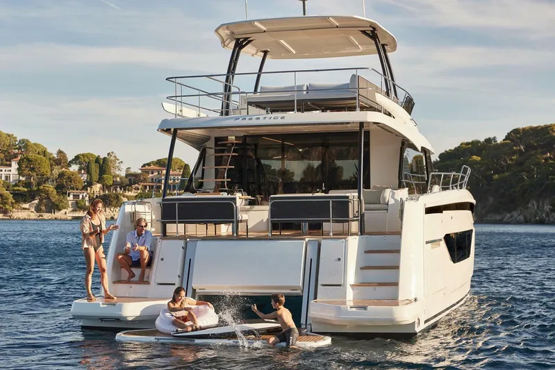 M3400 Yacht Photos Pics Manufacturer Provided Image: Prestige M48 yacht 2025 with people enjoying water activities in a scenic bay.