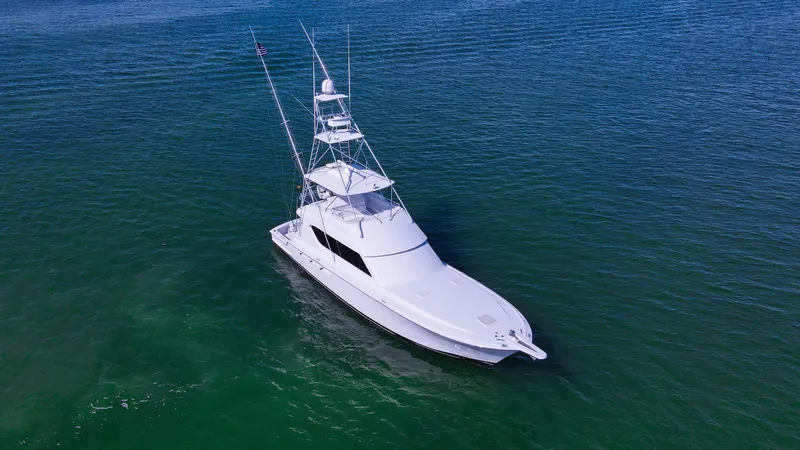 Rayne Check Yacht Photos Pics Aerial view of a 2001 Hatteras 65 yacht on calm blue waters.
