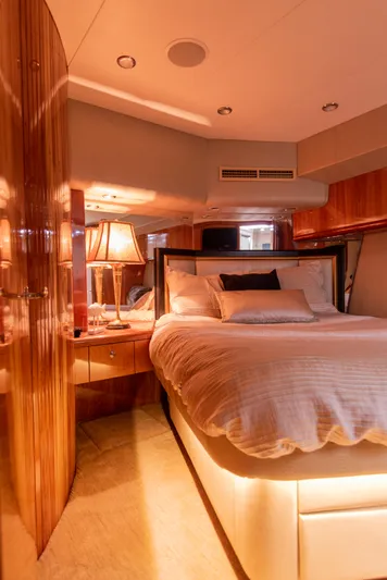 Rayne Check Yacht Photos Pics Luxurious bedroom interior of 2001 Hatteras 65 yacht with elegant lighting and wood finishes.