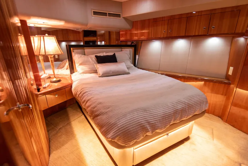Rayne Check Yacht Photos Pics Luxurious bedroom interior of a 2001 Hatteras 65 yacht with elegant wood finishes.