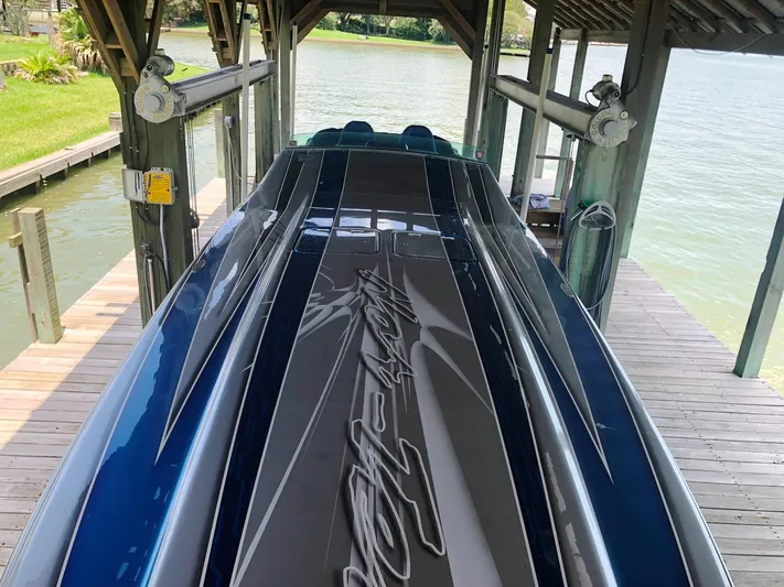  Yacht Photos Pics 2013 Nor-Tech 477 SPX Vee Bottom boat docked under a wooden shelter.