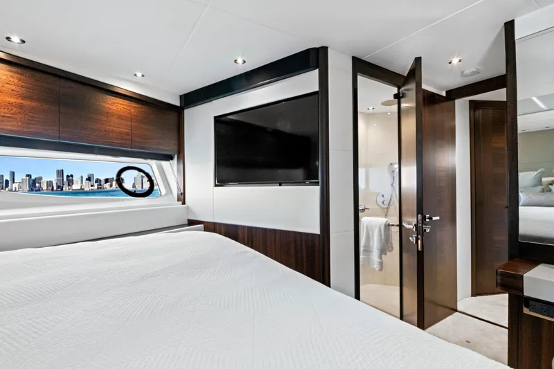 Misty K Yacht Photos Pics Luxurious 2024 Sunseeker 76 Yacht bedroom with city skyline view through window.