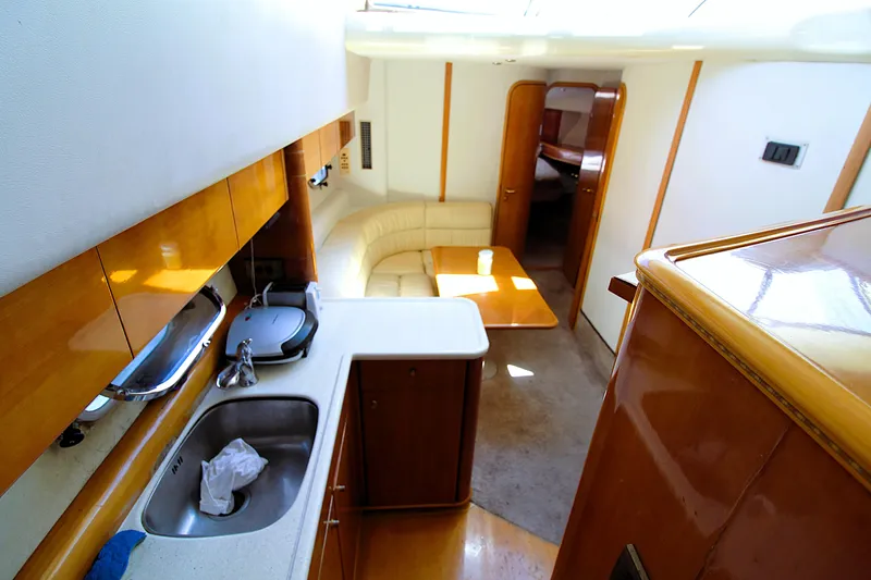 Empty Pockets Yacht Photos Pics Interior of 1997 Viking Sport Cruisers 48SC yacht, featuring kitchen and seating area.