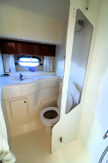 Empty Pockets Yacht Photos Pics 1997 Viking Sport Cruisers 48SC yacht bathroom with toilet, sink, and porthole window.
