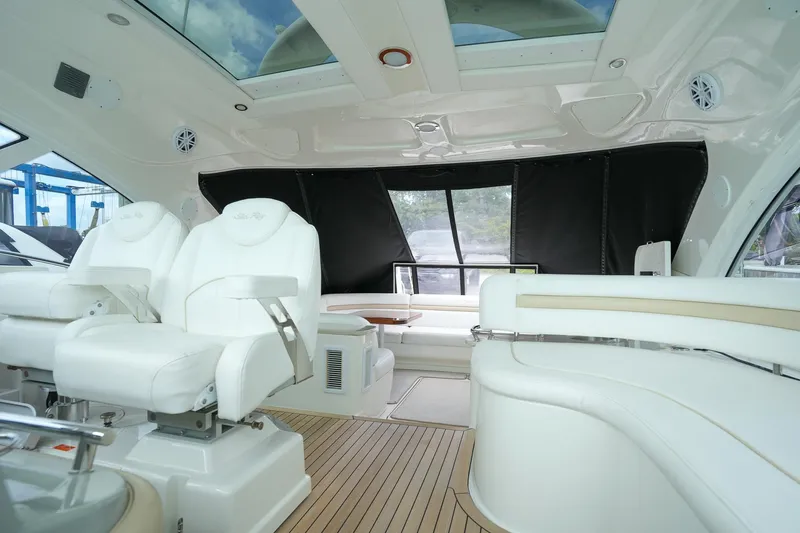  Yacht Photos Pics Luxurious interior of 2010 Sea Ray 500 Sundancer yacht with white seating and wooden flooring.