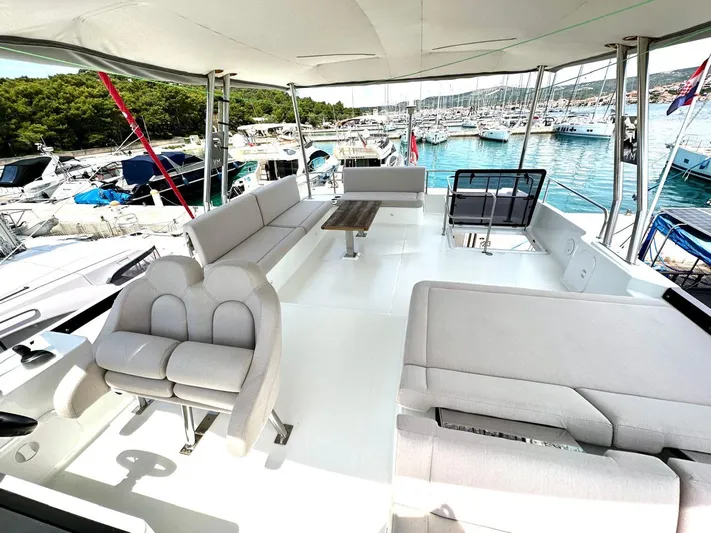  Yacht Photos Pics Spacious deck of 2021 Fountaine Pajot MY6 yacht with comfortable seating and scenic marina view.