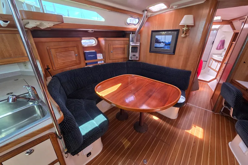  Yacht Photos Pics Interior of 2007 Catalina 42 MkII sailboat with cozy dining area and wooden finishes.
