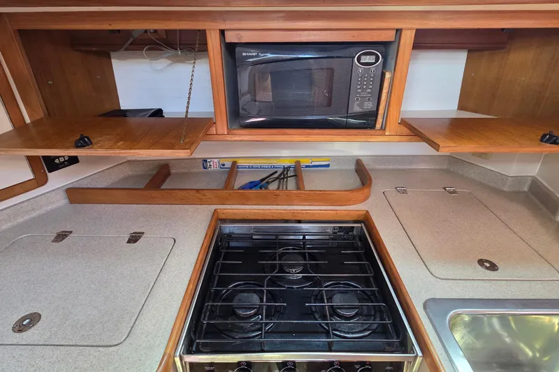  Yacht Photos Pics Catalina 42 MkII 2007 yacht kitchen with stove, microwave, and wooden cabinets.
