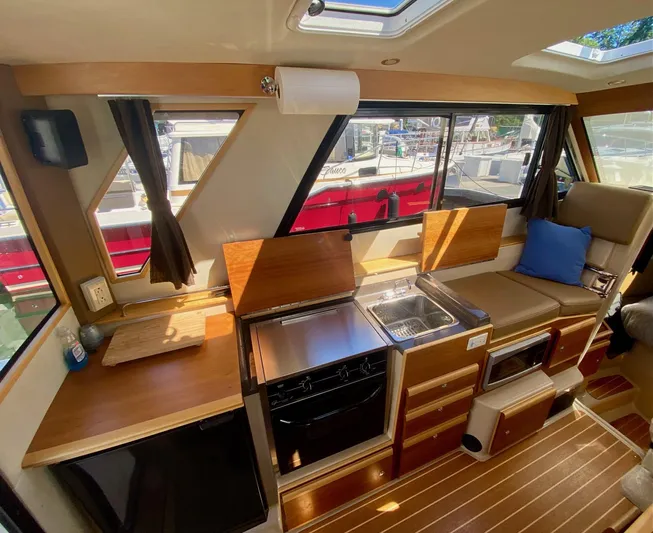 Sea Dreamer Yacht Photos Pics Interior of 2014 Cutwater 30 Sedan with kitchen and seating area.