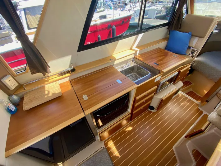 Sea Dreamer Yacht Photos Pics Interior of 2014 Cutwater 30 Sedan boat with wooden countertops and seating.