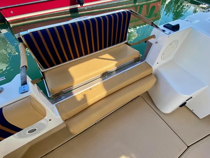Sea Dreamer Yacht Photos Pics 2014 Cutwater 30 Sedan boat seating area with striped cushions and beige upholstery.