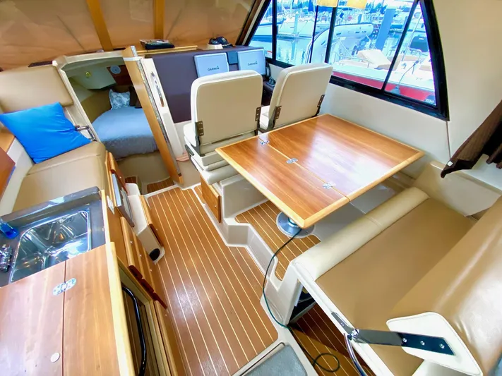 Sea Dreamer Yacht Photos Pics 2014 Cutwater 30 Sedan interior with wood accents, dining area, and helm station.