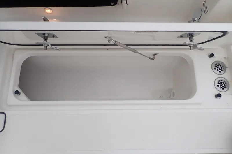  Yacht Photos Pics 2024 Pursuit S 288 Sport boat storage compartment with open lid and drainage system.