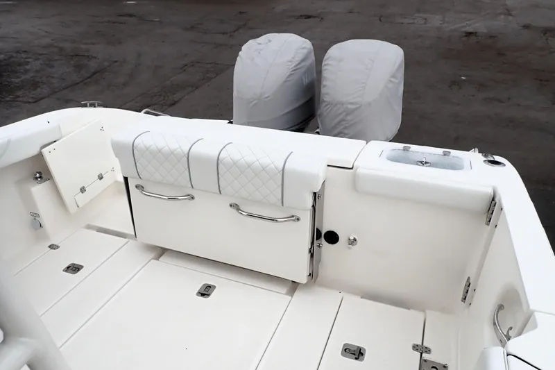  Yacht Photos Pics 2024 Pursuit S 288 Sport boat interior with cushioned seating and covered engines.