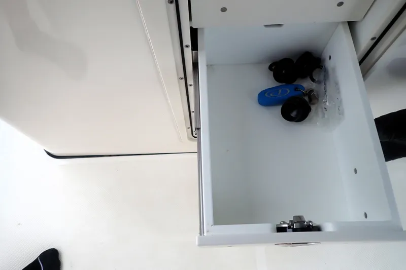  Yacht Photos Pics Open drawer in 2024 Pursuit S 288 Sport boat, containing keys and small items.