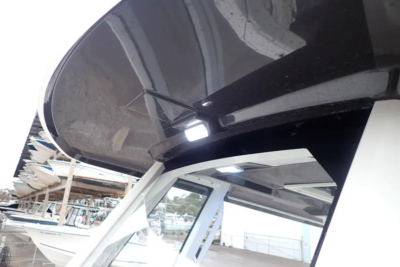  Yacht Photos Pics 2024 Pursuit S 288 Sport boat with sleek black canopy and modern design.