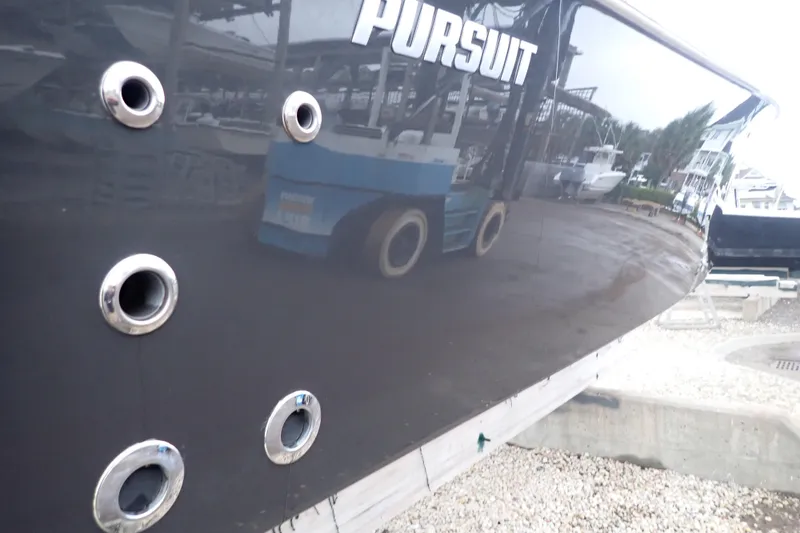  Yacht Photos Pics 2024 Pursuit S 288 Sport boat hull with visible portholes and reflection.
