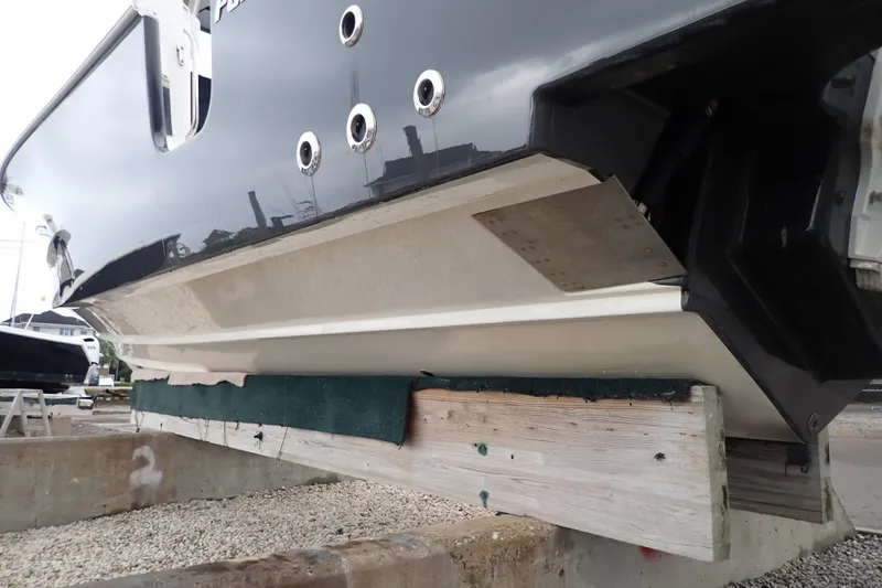  Yacht Photos Pics 2024 Pursuit S 288 Sport boat hull on dry dock, showcasing sleek design and craftsmanship.