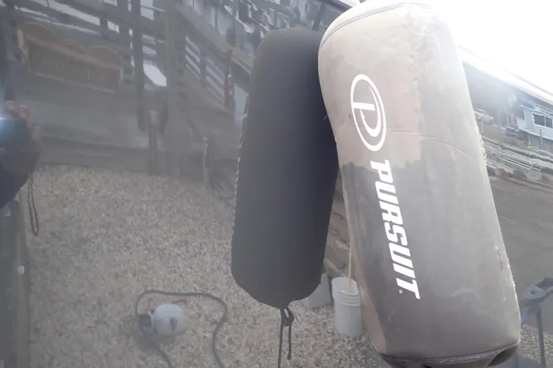  Yacht Photos Pics 2024 Pursuit S 288 Sport boat with protective fenders at a dock.