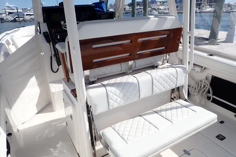  Yacht Photos Pics 2024 Pursuit S 288 Sport boat interior with white quilted seating and wooden accents.