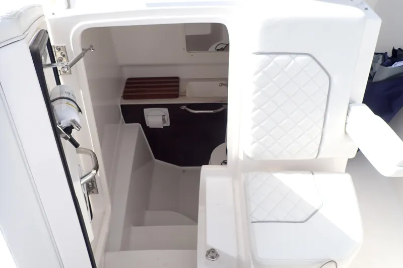  Yacht Photos Pics 2024 Pursuit S 288 Sport boat interior with white quilted seating and compact cabin space.