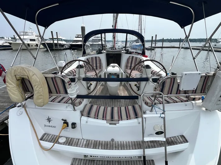 Miss Charlotte Yacht Photos Pics 2007 Jeanneau Sun Odyssey 39i sailboat with striped seating at marina dock.