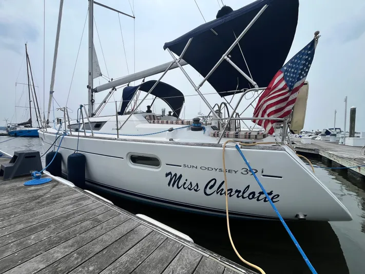 Miss Charlotte Yacht Photos Pics 2007 Jeanneau Sun Odyssey 39i sailboat docked, named "Miss Charlotte," with American flag.