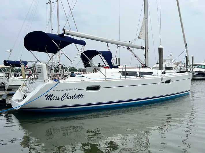 Miss Charlotte Yacht Photos Pics 2007 Jeanneau Sun Odyssey 39i sailboat docked, named "Miss Charlotte," with blue canopy.