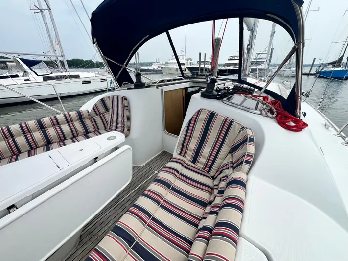 Miss Charlotte Yacht Photos Pics 2007 Jeanneau Sun Odyssey 39i sailboat cockpit with striped cushions and marina view.