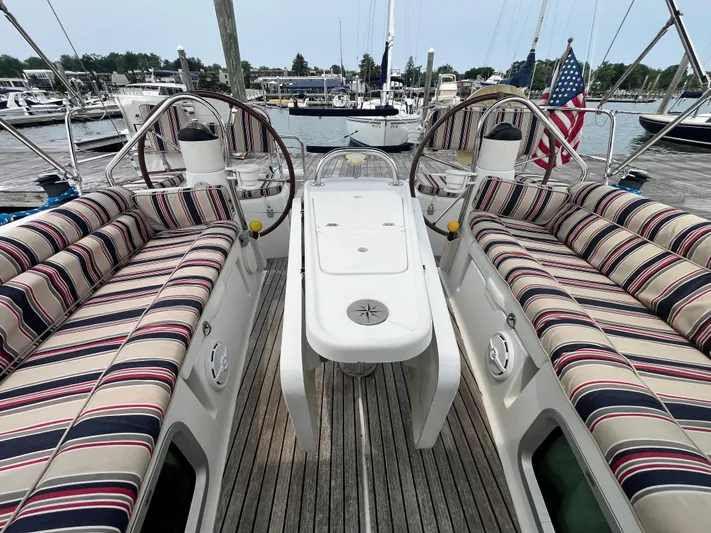 Miss Charlotte Yacht Photos Pics 2007 Jeanneau Sun Odyssey 39i sailboat cockpit with striped seating and dual steering wheels.
