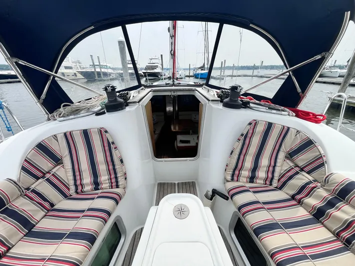 Miss Charlotte Yacht Photos Pics 2007 Jeanneau Sun Odyssey 39i cockpit with striped cushions, docked at marina.