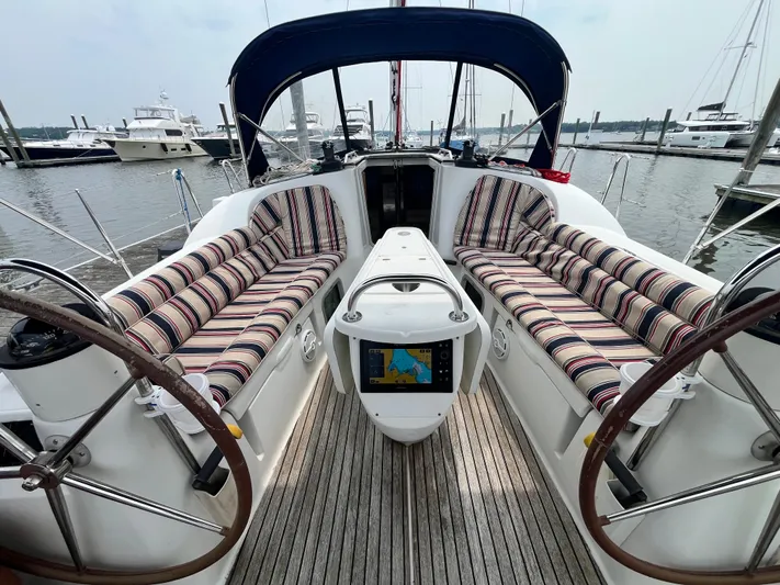 Miss Charlotte Yacht Photos Pics 2007 Jeanneau Sun Odyssey 39i sailboat cockpit with striped cushions and navigation system.