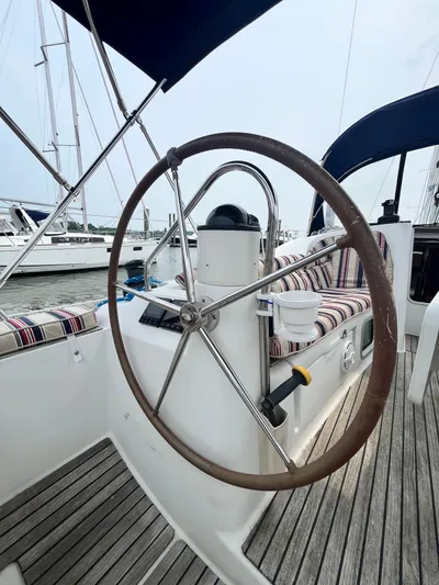 Miss Charlotte Yacht Photos Pics 2007 Jeanneau Sun Odyssey 39i sailboat cockpit with steering wheel and striped seating.