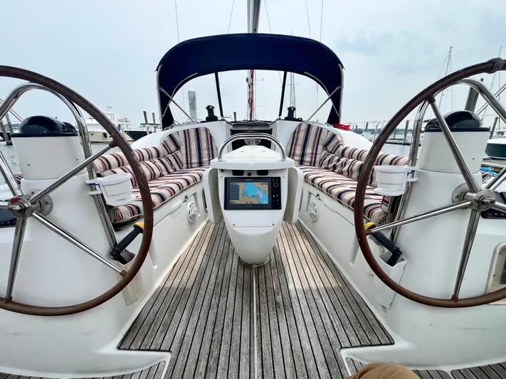 Miss Charlotte Yacht Photos Pics 2007 Jeanneau Sun Odyssey 39i sailboat cockpit with dual steering wheels and striped seating.