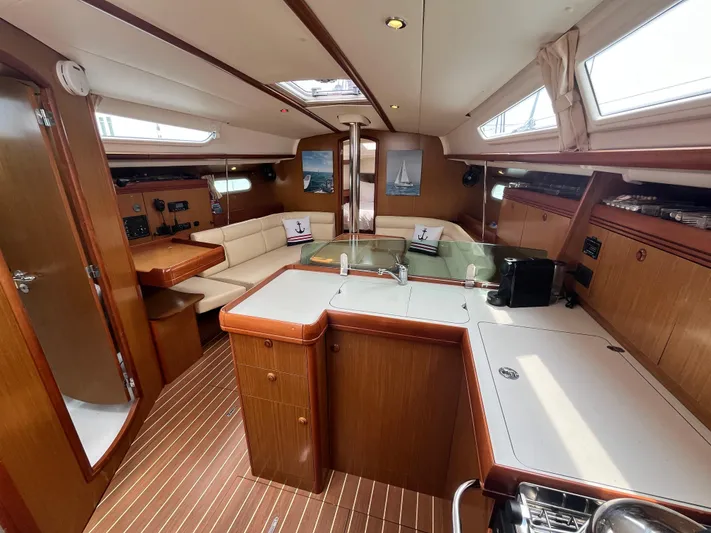 Miss Charlotte Yacht Photos Pics Interior of 2007 Jeanneau Sun Odyssey 39i yacht with wood finish and seating area.