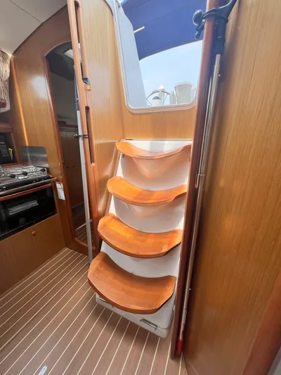 Miss Charlotte Yacht Photos Pics Interior of 2007 Jeanneau Sun Odyssey 39i yacht with wooden steps and galley view.