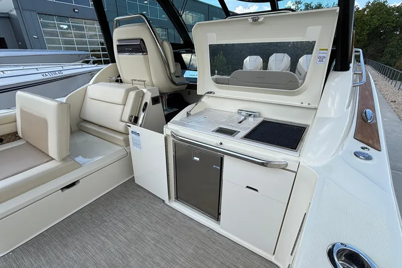 Yacht Photos Pics 2021 Chris-Craft Calypso 35 boat interior with seating and kitchenette area.