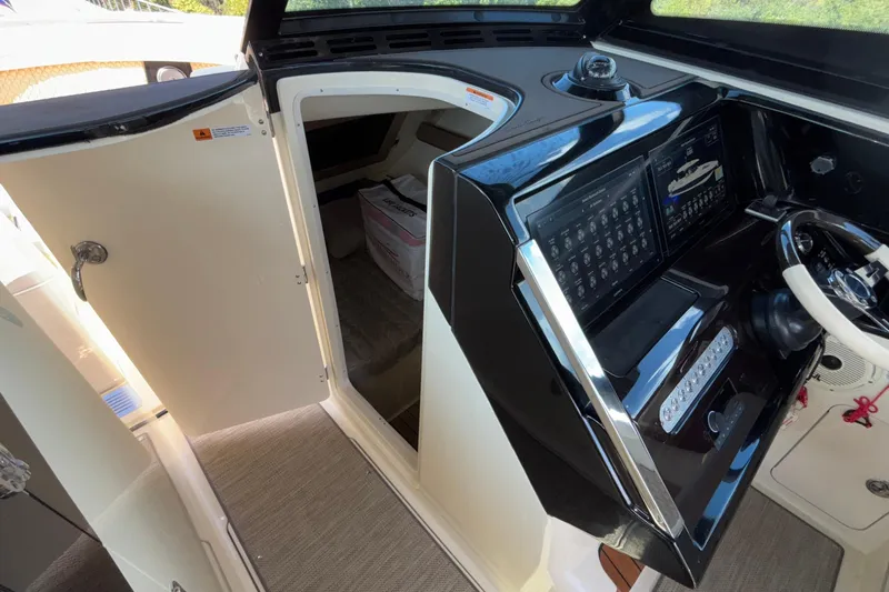  Yacht Photos Pics 2021 Chris-Craft Calypso 35 helm with open cabin door, showcasing modern controls.