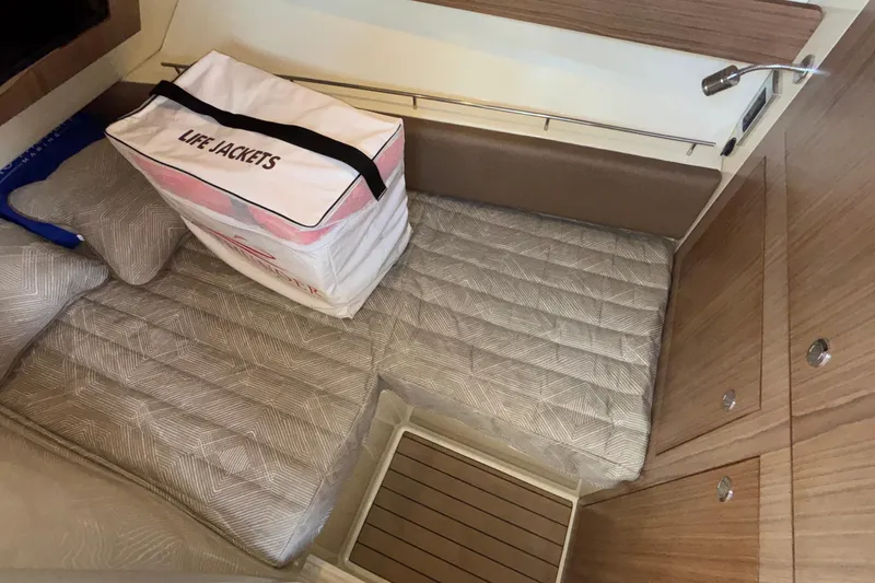  Yacht Photos Pics 2021 Chris-Craft Calypso 35 cabin interior with life jackets and cushioned seating.