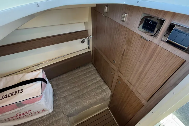  Yacht Photos Pics 2021 Chris-Craft Calypso 35 cabin interior with wood paneling and storage compartments.