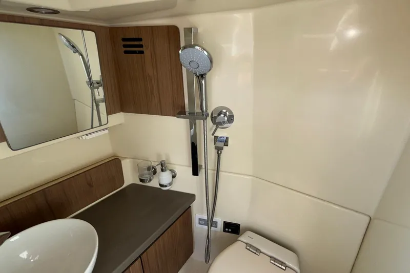  Yacht Photos Pics 2021 Chris-Craft Calypso 35 bathroom with modern fixtures and wooden accents.