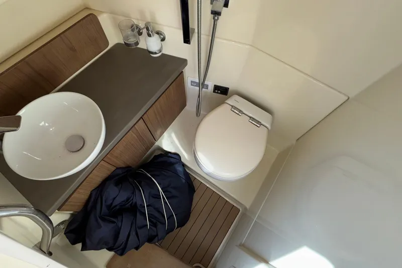  Yacht Photos Pics 2021 Chris-Craft Calypso 35 bathroom with sink, toilet, and wooden cabinetry.